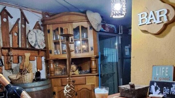 A bar area with wooden furniture, a clock, and a sign that says "LIFE is good." - Hotel Cordillera Cabildo (Cabildo)