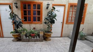 A courtyard with three doors, a central window, and potted plants. - Hotel Cordillera Cabildo (Cabildo)