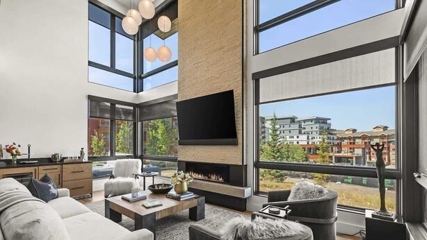 A modern living room with a fireplace, large windows, and a flat-screen TV. - Abode at Moose Ridge, private hot tub, ski access, modern home (Park City)