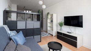 En moderne stue med sofa, fjernsyn og indbyggede reoler.