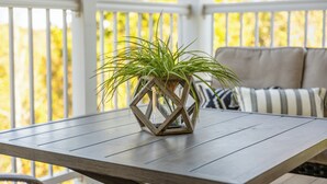 Una mesa de madera con una jardinera hexagonal que contiene una planta verde.