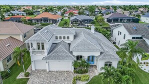 Une grande maison à plusieurs étages, dotée d’une allée spacieuse, d’un garage et d’une pelouse bien entretenue.