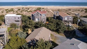 A coastal residential area with houses, a beach, and a clear view of the ocean.