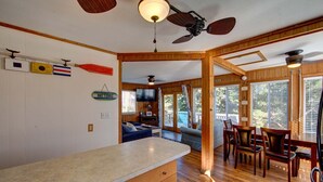 A spacious kitchen with wooden cabinets, a large island, and a ceiling fan.