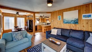 A cozy cabin interior with a dining area, kitchen, and living room.