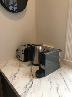 Eine Küchenarbeitsplatte mit Toaster, Wasserkocher und Kaffeemaschine.