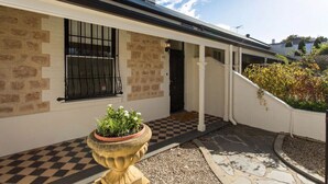 A building with a checkered floor, a potted plant, and a number '115' on the wall. - North Adelaide - Row Cottage - “Monte” (North Adelaide)