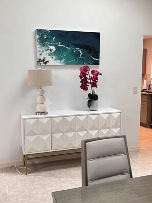 Un comedor moderno con un armario blanco, una mesa y una silla.