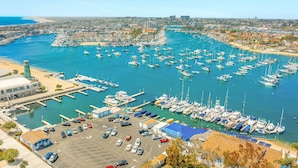 Uma marina com vários barcos atracados, uma área de estacionamento e um edifício com telhado azul.