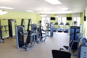 A gym with various exercise machines, treadmills, and weight stations.