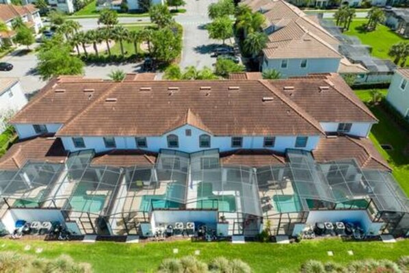 A large, multi-story house with a central courtyard and multiple swimming pools.