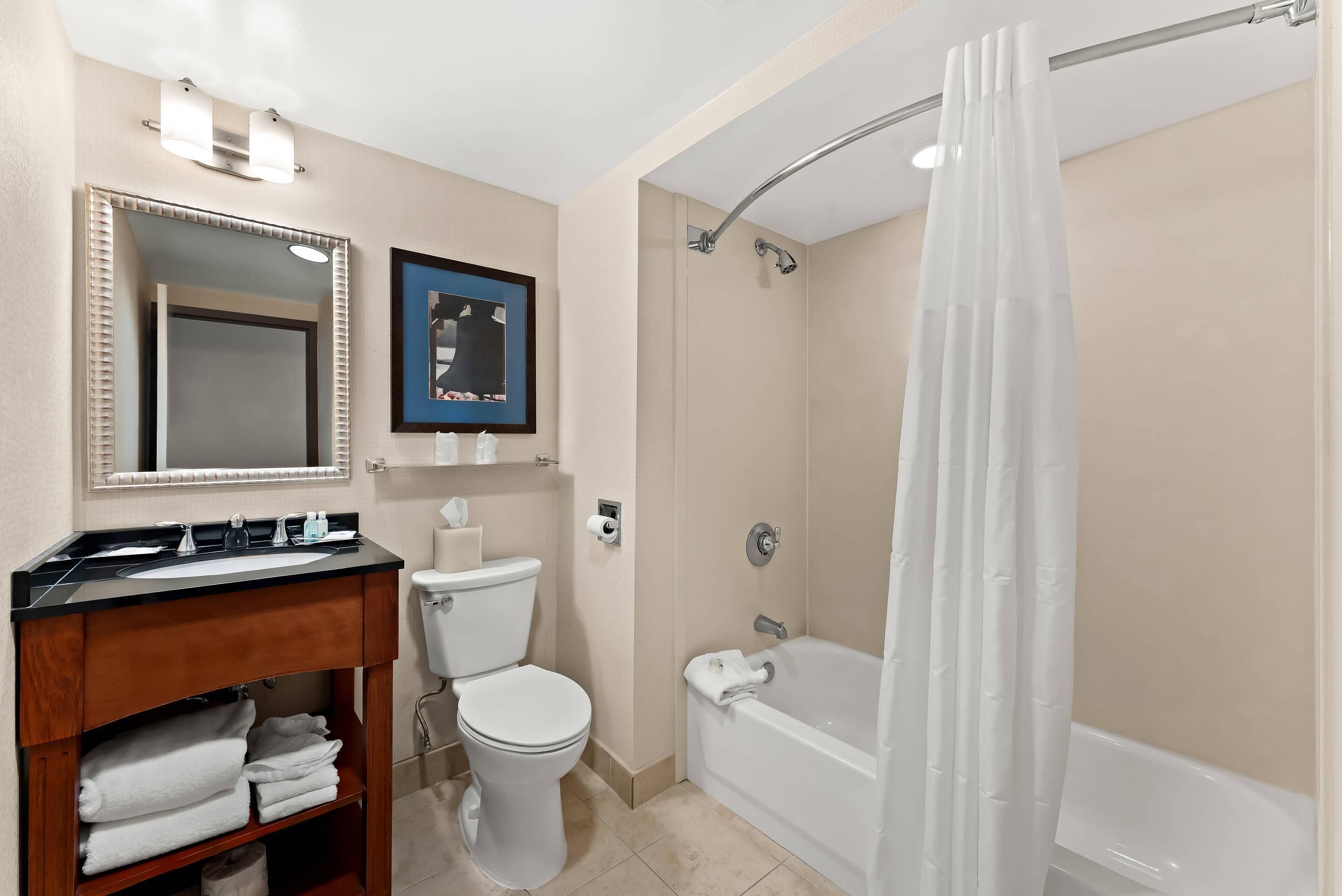 A bathroom with a sink, toilet, shower, and bathtub.