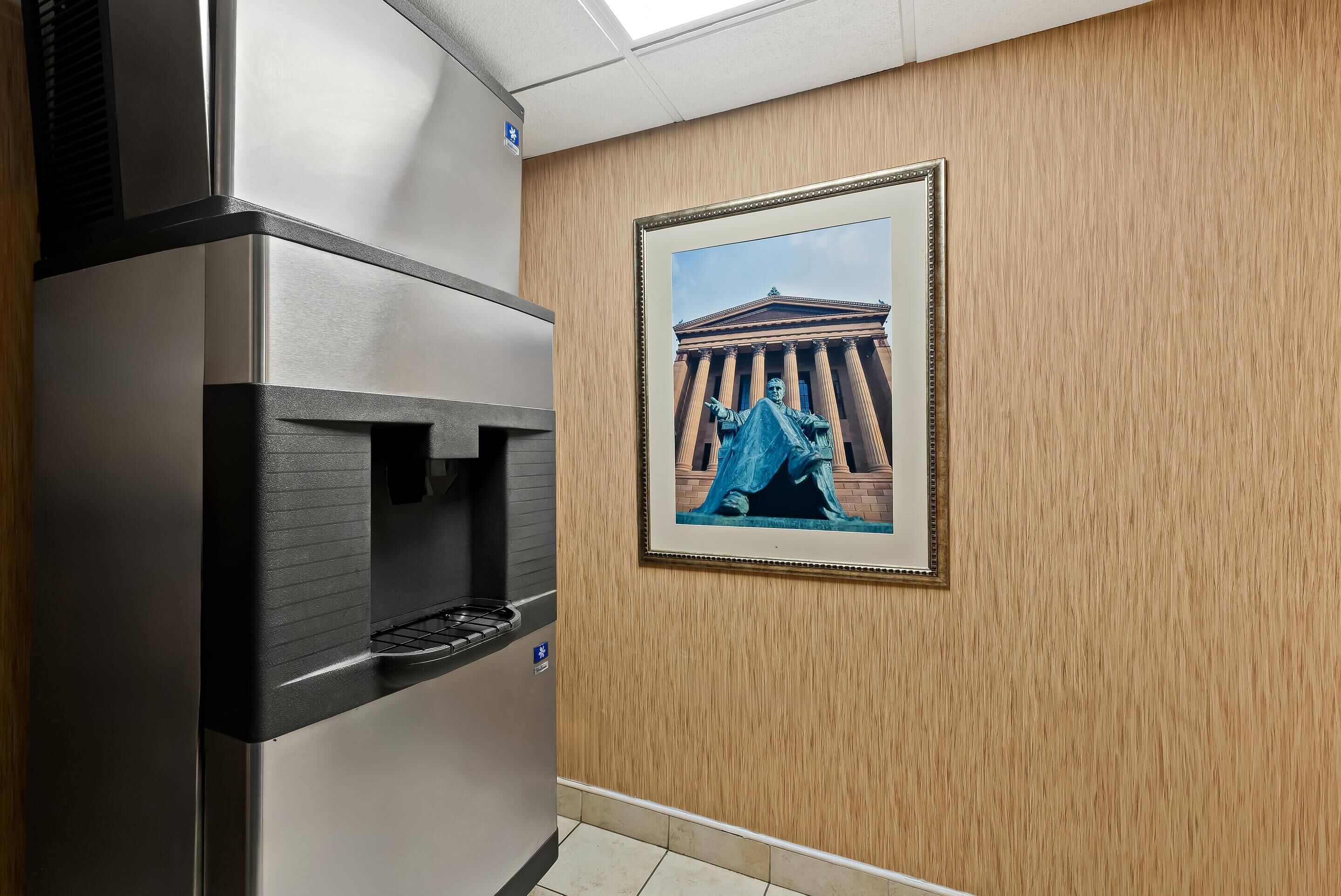Una cocina con campana extractora de acero inoxidable y un cuadro enmarcado de un edificio clásico en la pared.