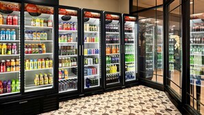A row of Coca-Cola branded ice cold beverage dispensers stocked with various drinks. - Quality Hotel Philadelphia Airport (Essington)