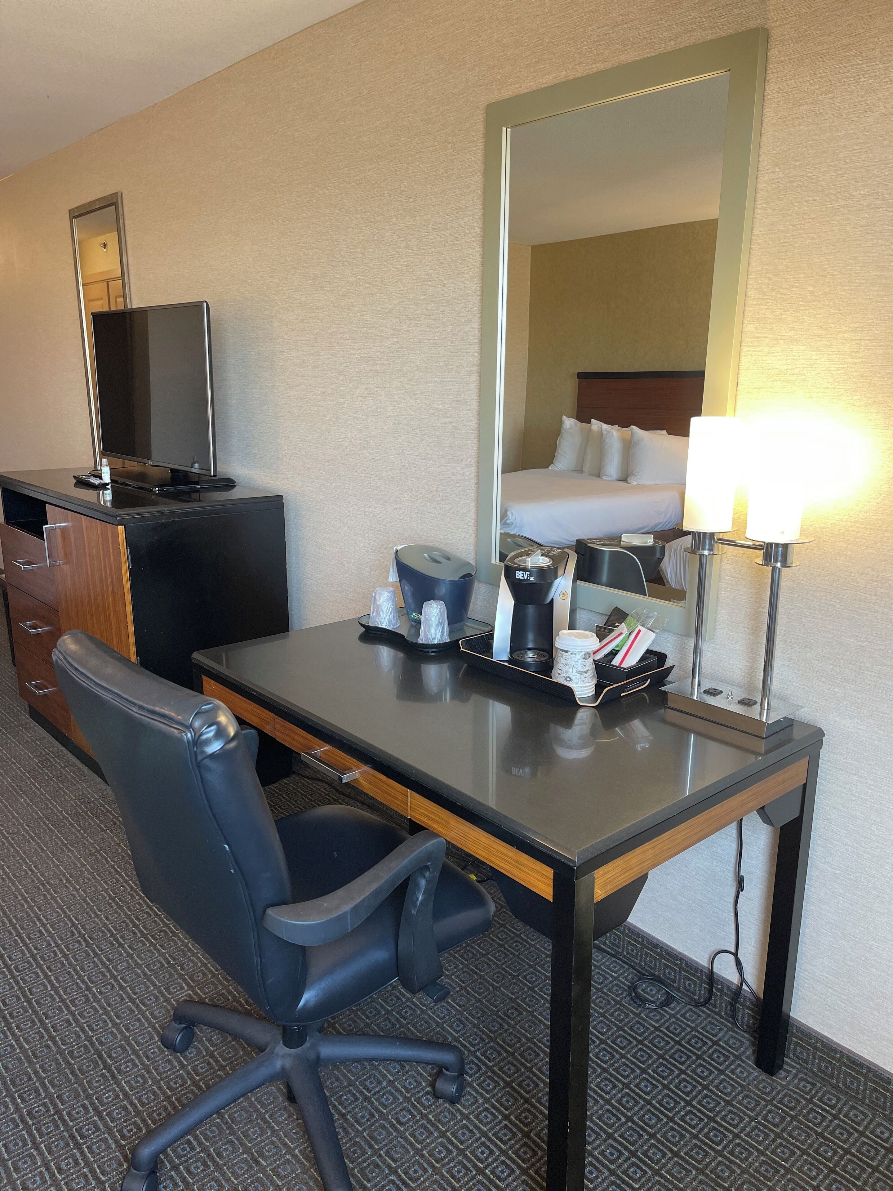 Una habitación de hotel con escritorio, silla y cama.