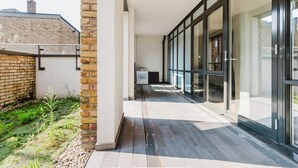 A modern building with a brick facade, large glass windows, and a flat roof. - Chic St. John's Wood 1BR w/ Elevator, Fully Furnished, by Blueground (London)