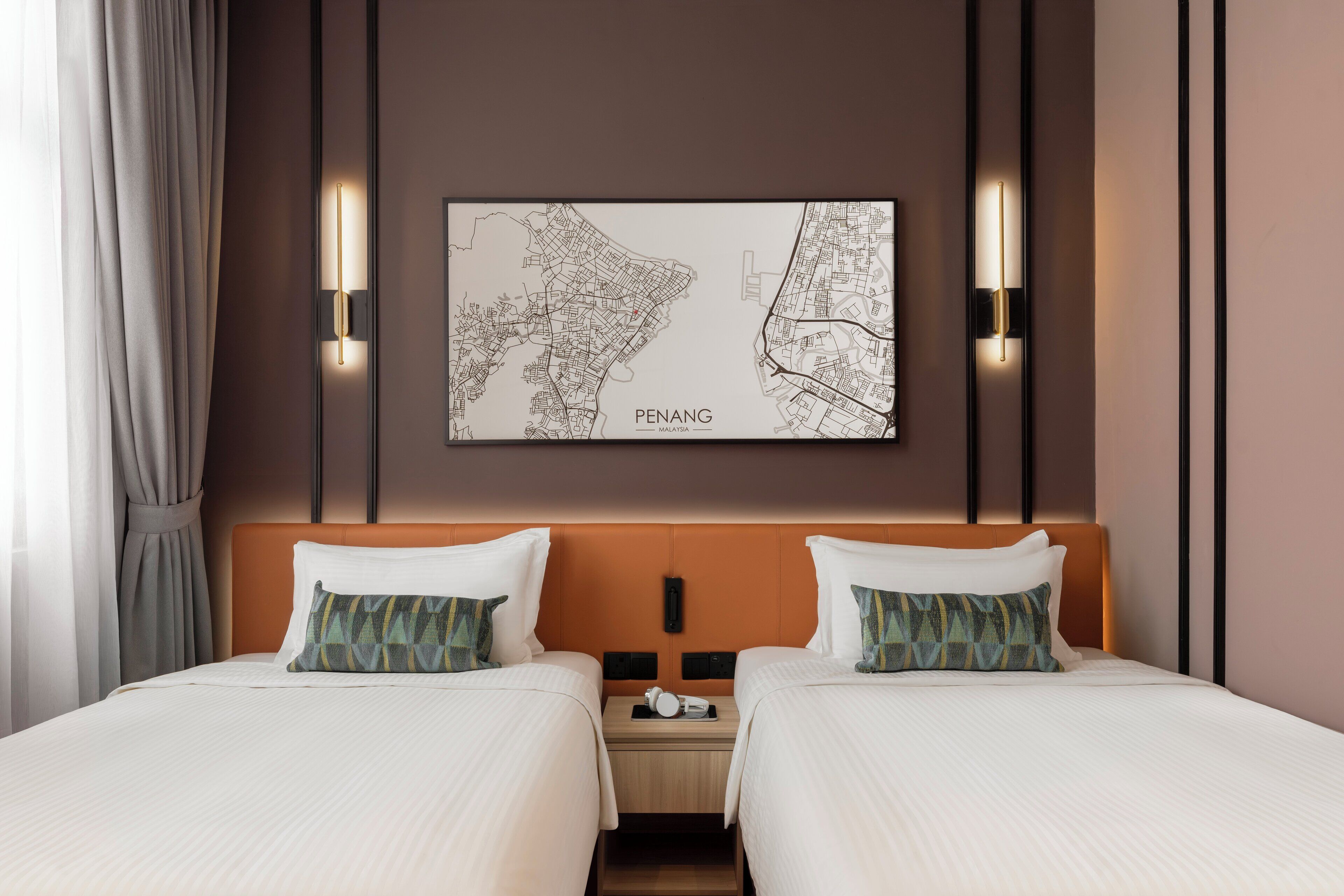 A hotel room with two beds, a map on the wall, and a nightstand with a phone.