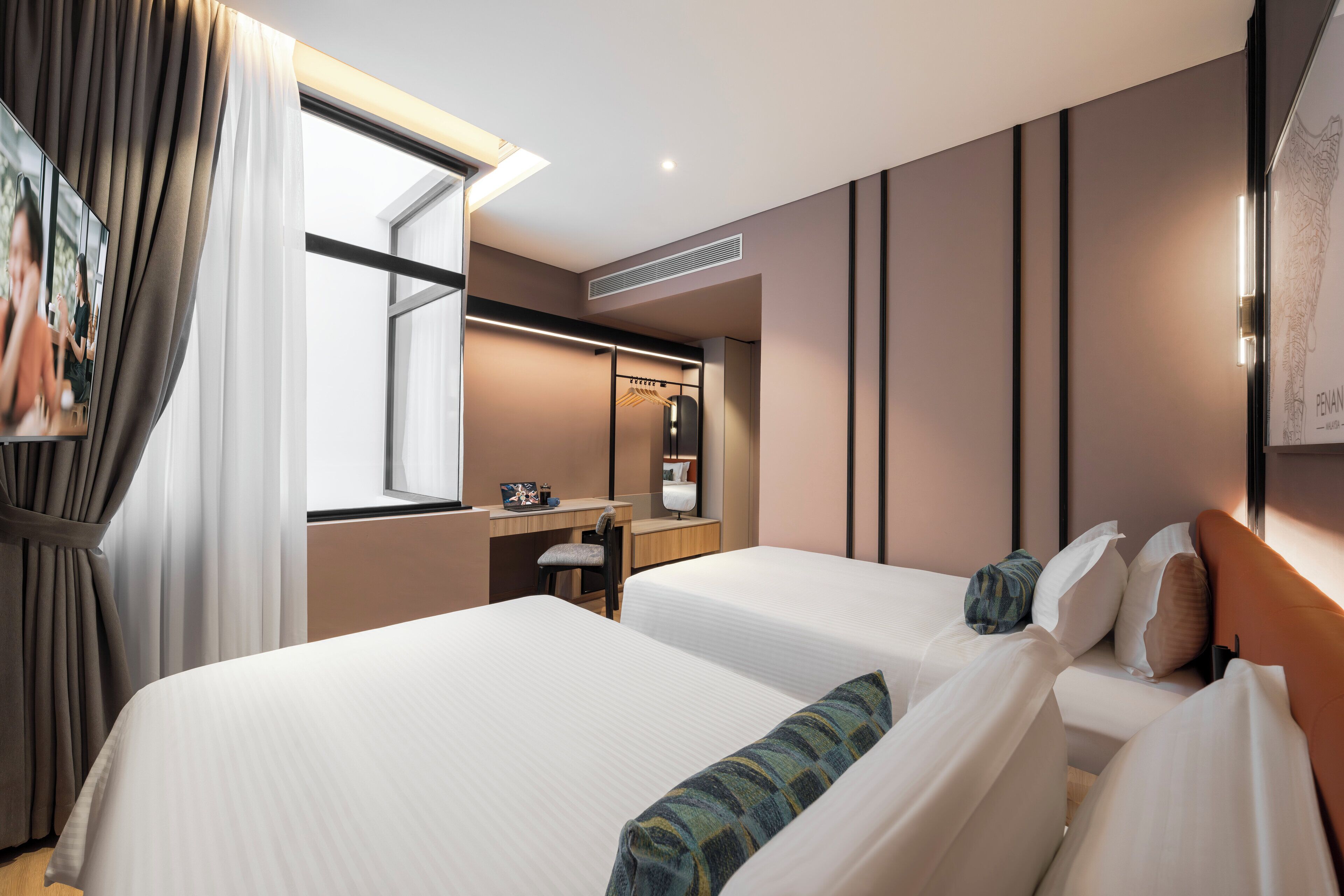 Habitación de hotel con dos camas, un escritorio, un espejo y una ventana con cortinas.