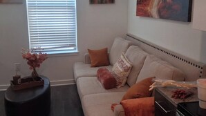 A living room with a sofa, a coffee table, and a painting of the Eiffel Tower. - Radiant and Cozy (Memphis)