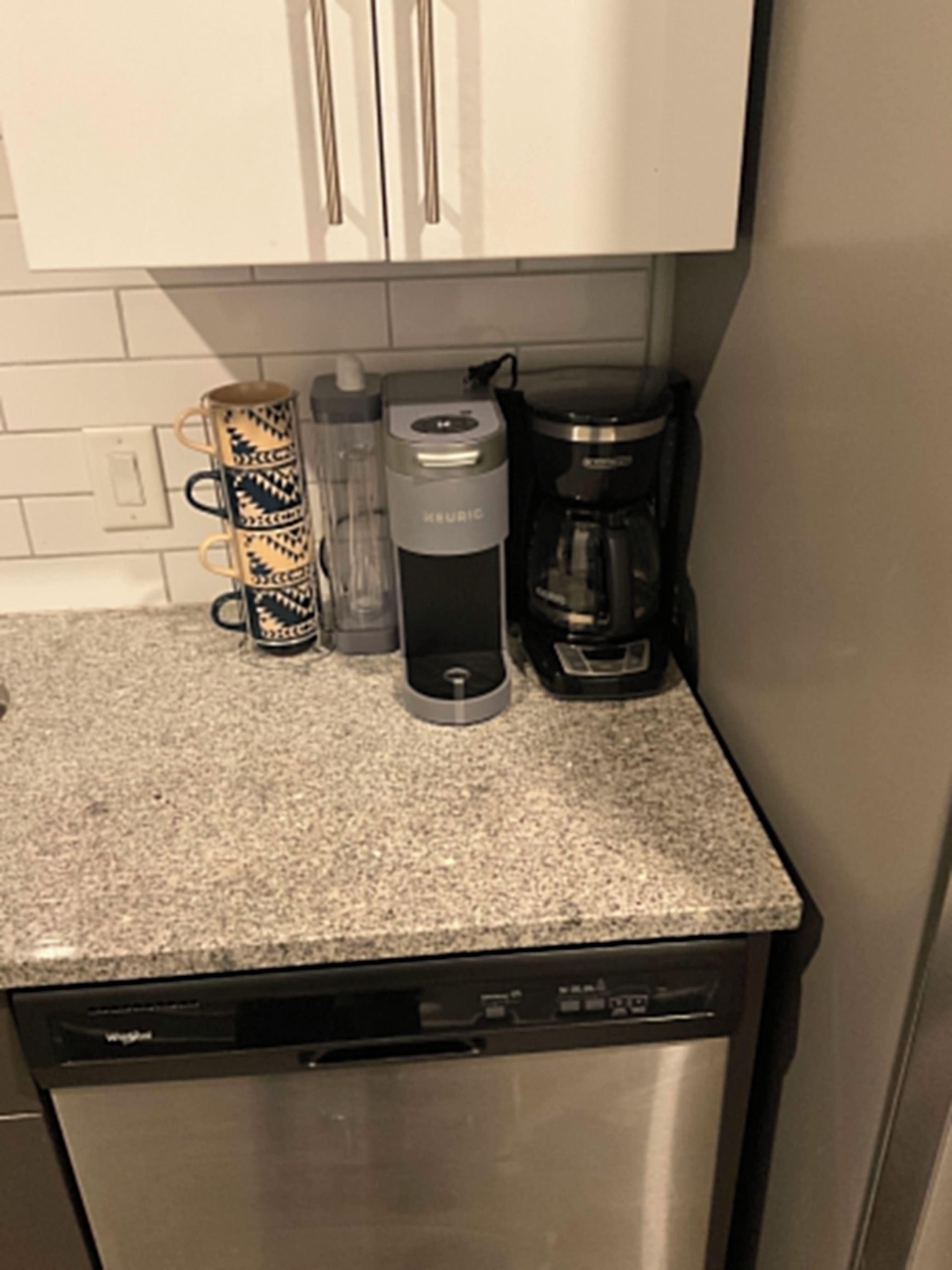 Ett kök med en kaffebryggare, en vattenautomat och en diskmaskin.