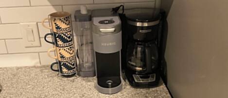 Ett kök med en kaffebryggare, en vattenautomat och en diskmaskin.