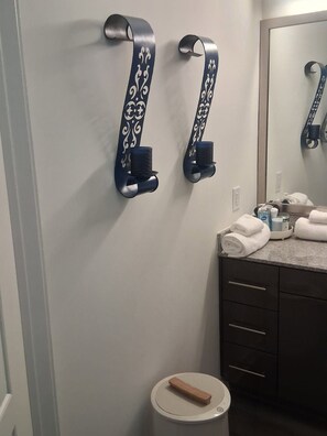A bathroom with a towel rack, a toilet, and a mirror.