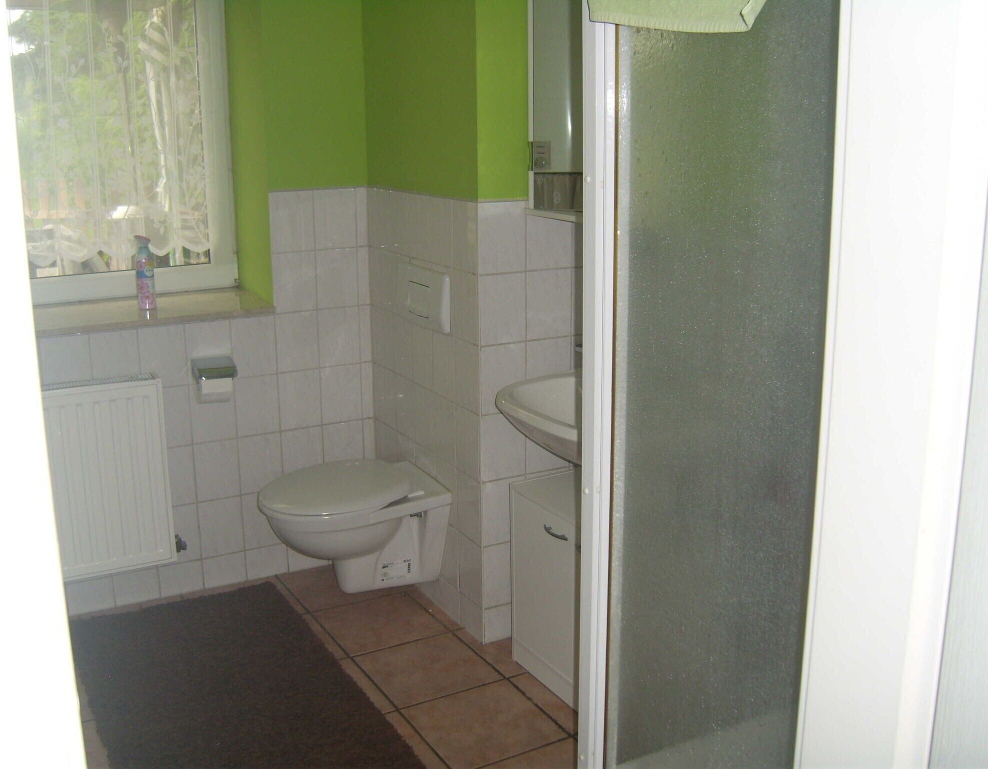 Un bagno piccolo con WC, lavandino e doccia.