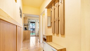 A hallway with wooden cabinets, a mirror, and a view into another room. - Holiday Apartment at Federower Hofsee: Lake View, Private Terrace & Wi-Fi (Kargow)