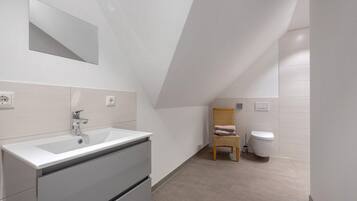 Ein modernes Badezimmer mit Waschbecken, Spiegel und Toilette.