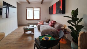 Una sala de estar moderna con sofá, mesa de centro y ventilador de techo.