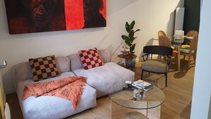 Una sala de estar moderna con un sofá, una mesa de centro de vidrio y un comedor con sillas y una mesa.
