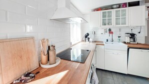 Eine moderne Küche mit weißen Schränken, einer Holz Arbeitsplatte und einem eingebauten Geschirrspüler.