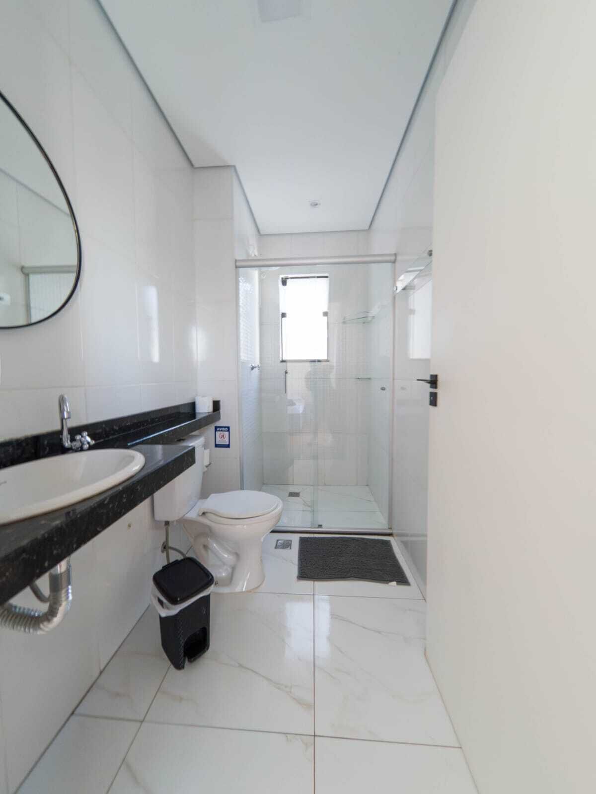 A modern bathroom with a sink, toilet, and shower area.