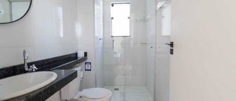 A modern bathroom with a sink, toilet, and shower area.