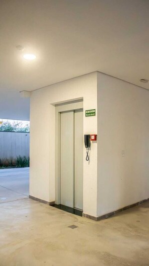 Entrada de hotel com porta, telefone e placa.