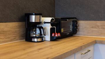 Una cocina con cafetera, tostadora y microondas sobre una encimera de madera.
