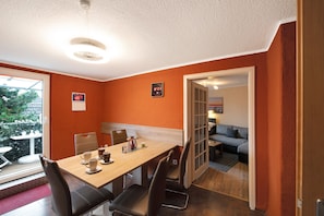 Un comedor con mesa de madera, sillas y vista al exterior a través de una ventana.
