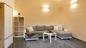 Un salon moderne avec un canapé gris, une table basse blanche et un tapis gris.