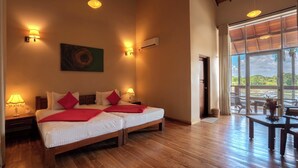 A hotel room with two beds, a painting on the wall, and a view of the outdoors through a large window. - Lavendish Wild Wilpattu (Nochchiyagama)