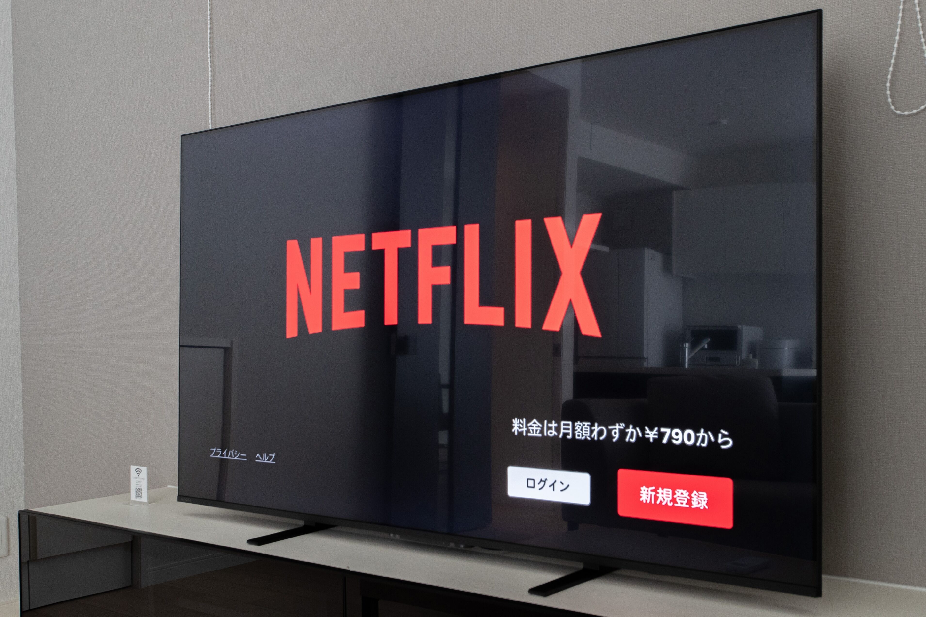 Een flatscreen-tv met het Netflix-logo en Japanse tekst die een maandelijkse kosten vanaf ¥790 aangeeft.