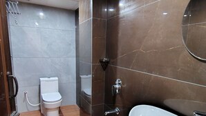 Moderni kylpyhuone, jossa on wc, pesuallas ja peili.