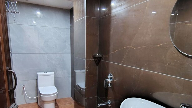 Un baño moderno con inodoro, lavamanos y espejo.