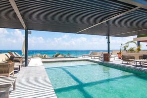 An infinity pool with lounge chairs and a view of the ocean. - 1 Block to Beach, Oceanview Rooftop Pools & Lounge (Playa del Carmen)