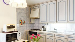 A kitchen with a microwave, toaster, stove, sink, and cabinets. - Eat and live like locals (Shinagawa City)