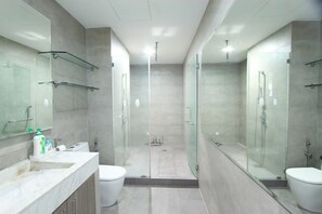 Căn hộ Deluxe, quang cảnh thành phố | Phòng tắm | Buồng tắm vòi sen, máy sấy tóc, dép đi trong nhà, khăn tắm 