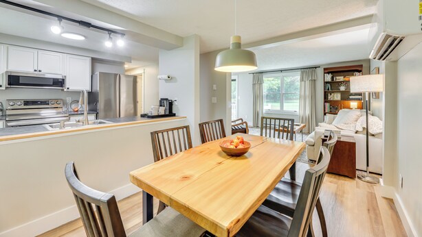 Cocina moderna con isla central, mesa de comedor y sillas. Incluye refrigerador, horno y microondas.