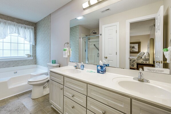 A bathroom with a double sink, toilet, bathtub, and a large mirror. - 4 Mi to Brookgreen Gardens: Murrells Inlet Condo (Murrells Inlet)