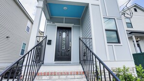 A two-story building with a black front door, a blue awning, and a brick base. - < 2 Mi to Jackson Square: New Orleans Home w/ Yard (New Orleans)