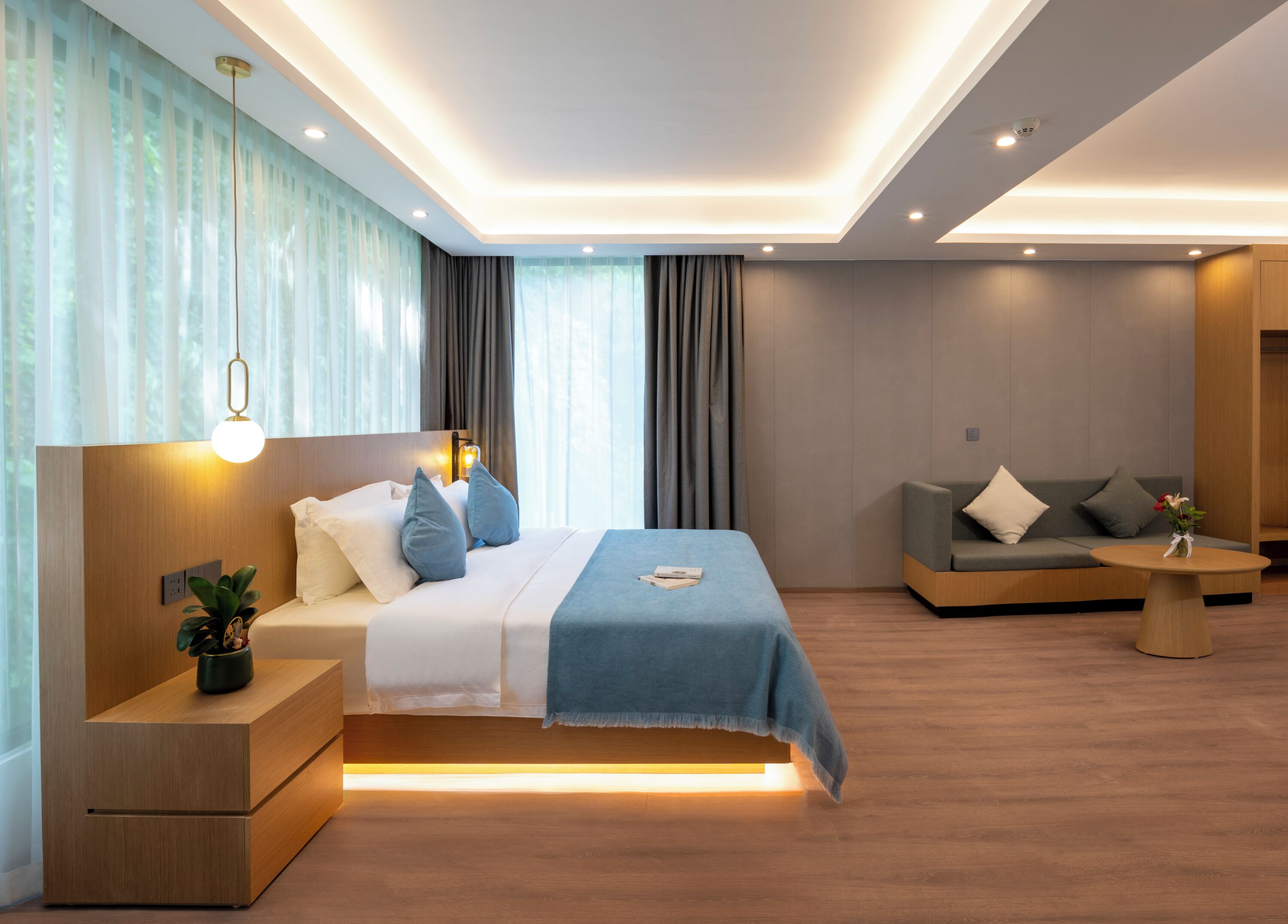 Una habitación de hotel moderna con cama, mesita de noche y sofá.