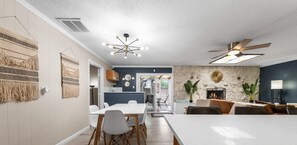 A modern dining area with a white table, chairs, and a ceiling fan. - The Gabriel Getaway - 6BR Oasis - An Irvie Home (Albuquerque)